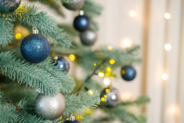 Рождественская елка с голубыми и серебряными игрушками. Празднично украшенная елка с гирляндами. Символ нового года. - Фото, изображение