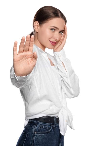 Embarrassed young woman covering face with hand on white background - Photo, Image