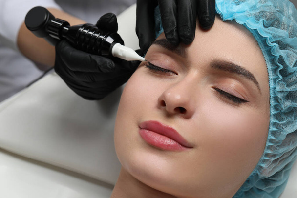 Young woman undergoing procedure of permanent eye makeup, closeup - Fotoğraf, Görsel