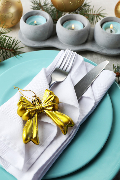 Christmas table setting in blue, golden and whitec olors on grey tablecloth background - Fotó, kép