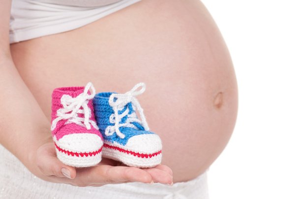 Έγκυος γυναίκα με μπότες του μωρού - Φωτογραφία, εικόνα