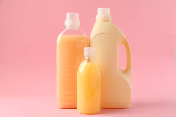 Bottles of laundry detergents on pink background - Foto, afbeelding