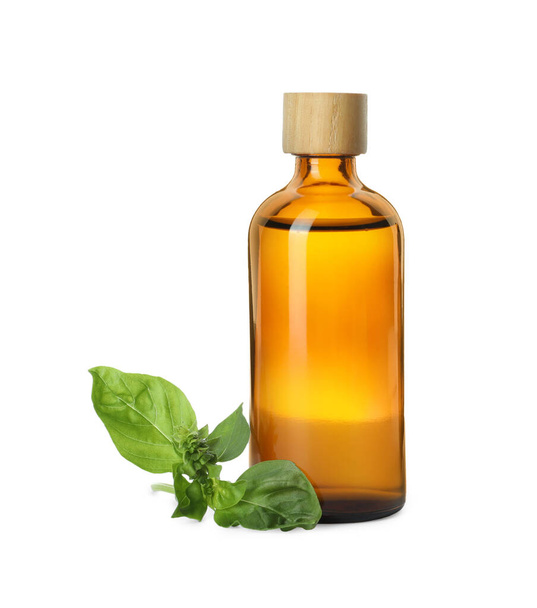Bottle of essential oil and basil on white background - Foto, afbeelding