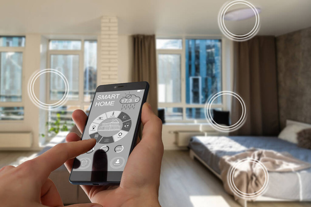 Akıllı bir evle ev ısısını kontrol etmek, telefonla yakın çekim yapmak. Evdeki akıllı aygıtları yönetmek için akıllı ev ve mobil uygulama kavramı. - Fotoğraf, Görsel
