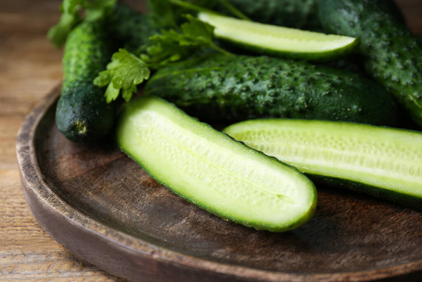 Fresh ripe cucumbers and parsley on wooden table, closeup - Fotoğraf, Görsel