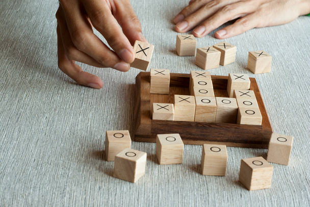 Tic tac toe παιχνίδι OX από ξύλινα μπλοκ με παίκτη χέρι - Φωτογραφία, εικόνα