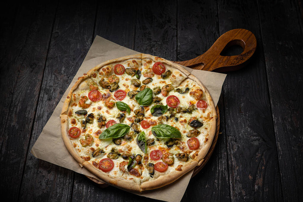 delicious pizza with cheese, greens, sauce in a restaurant - Foto, Bild