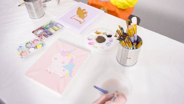 Pittura bambina con vernice acrilica su tela con sua madre per un progetto d'arte di apprendimento a distanza. - Foto, immagini