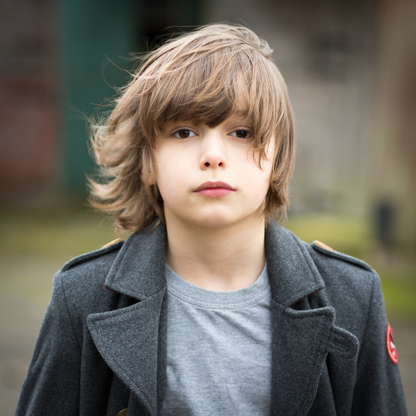 Chlapec v dlouhém kabátě, stojící v zahradě farmy - Fotografie, Obrázek