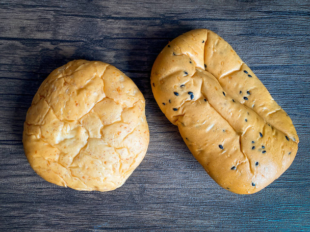 Целый хлеб на деревянном столе, готовый к употреблению - Фото, изображение