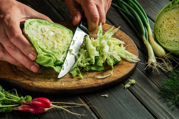 Gotować ręce wyciąć świeżą kapustę z nożem przed przygotowaniem żywności narodowej lub wegetariańskiej. Kuchnia chłopska - Zdjęcie, obraz