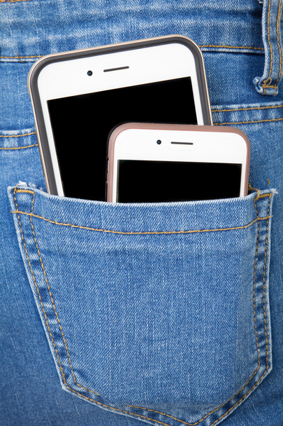 Telefone celular no bolso de trás das calças de ganga da menina
 - Foto, Imagem