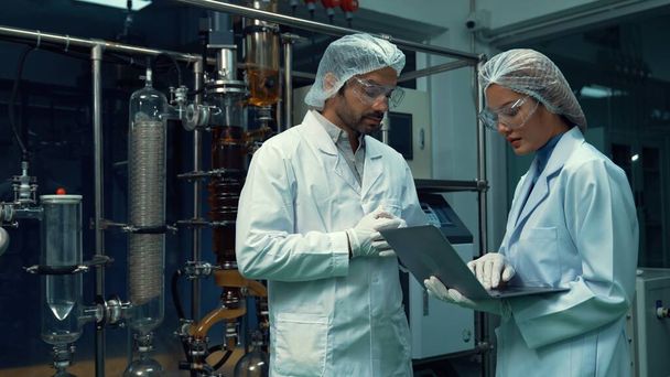 Twee wetenschapper in professioneel uniform werkzaam in laboratorium voor chemisch en biomedisch experiment - Foto, afbeelding