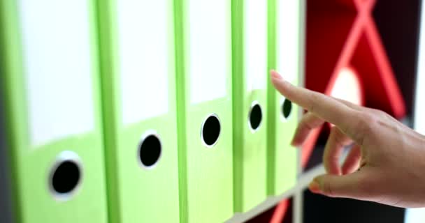 Γυναίκα χέρι ψάχνει για πράσινο ράφι φάκελο στο γραφείο closeup 4k ταινία αργή κίνηση. Έννοια διοίκησης επιχειρήσεων  - Πλάνα, βίντεο