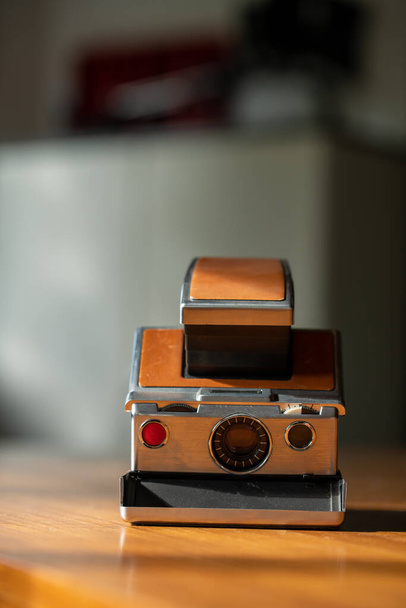 Cámara instantánea retro en un escritorio de madera de mediados de siglo. Polaroid. Foto de alta calidad - Foto, Imagen