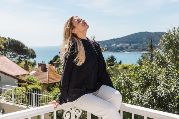 задоволена і блондинка позує біля будинків і моря на островах принцеси в Туреччині
  - Фото, зображення