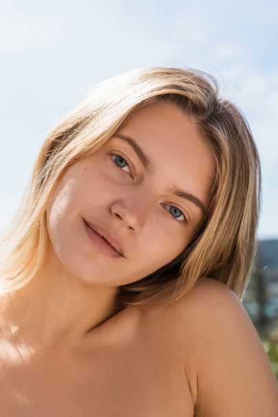 portrait of young blonde woman with bare shoulder looking at camera - Photo, Image