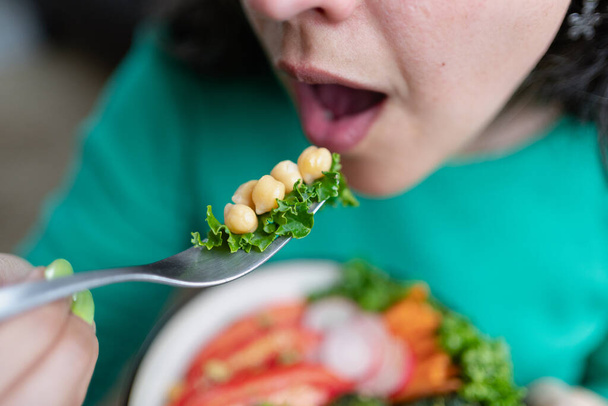 Die Frau steht kurz davor, einen Teil ihres vegetarischen Mittagessens zu essen. Großansicht der Bildunterschrift. Unerkennbare Person - Foto, Bild