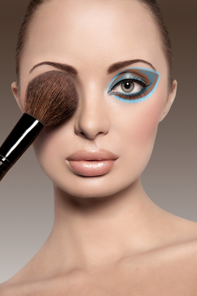 Retrato de una mujer hermosa con un pincel de maquillaje
 - Foto, Imagen