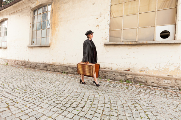 Woman walking with suitcases - 写真・画像