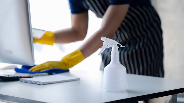 Person cleaning the room, the cleaner is wiping the desk in the company office. Cleaning staff. Concept of cleanliness in the organization. - Foto, Imagen
