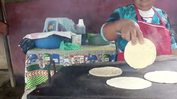 Tunnistamaton latinanainen kokkaamassa tortilloja vaatimattomassa kodissaan Nicaraguassa. - Materiaali, video