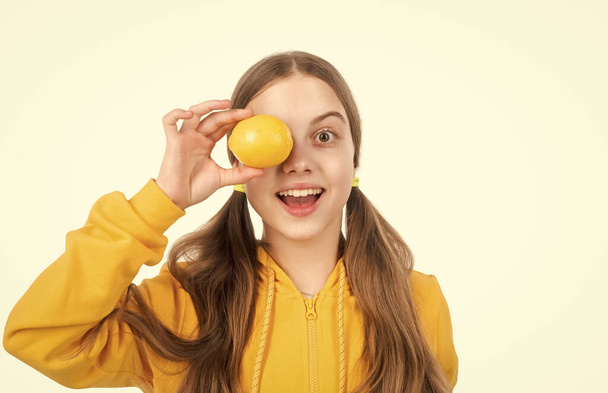 happy teen girl hold citrus lemon fruit with vitamins isolated on white, vitamin. - Фото, изображение