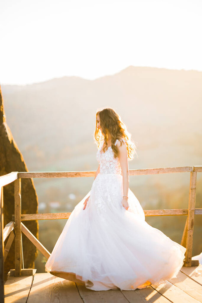 Beauty woman, bride with perfect white dress background mountains. - Fotó, kép