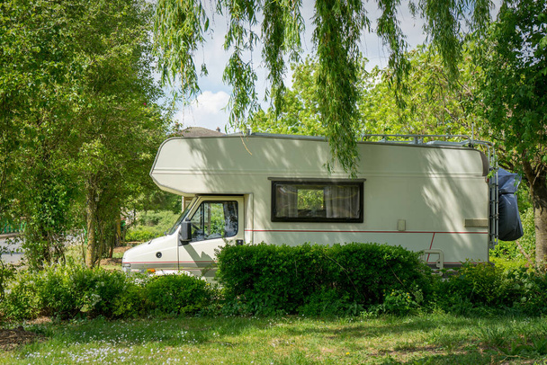Motorhome parked between trees in the middle of nature. High quality photo - Fotoğraf, Görsel