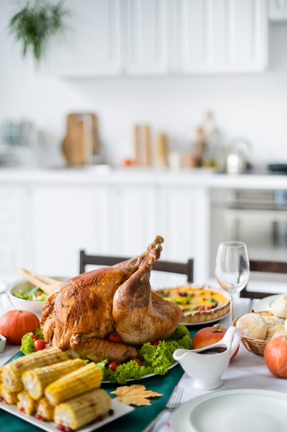 thanksgiving dinner with traditional roasted turkey and grilled corn in blurred kitchen - Foto, imagen