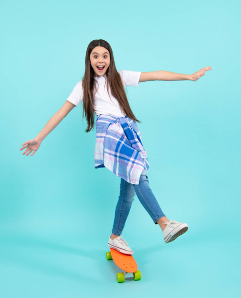 Fashion teenage lifestyle, beautiful teen girl with skateboard isolated on studio background. Happy teenager, positive and smiling emotions of teen girl - Фото, зображення