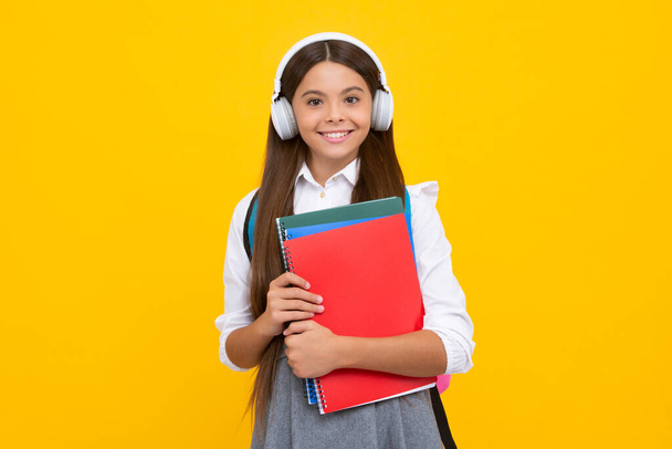 Student girl in headphones holding books. Education in school or college. Happy girl face, positive and smiling emotions - Fotoğraf, Görsel