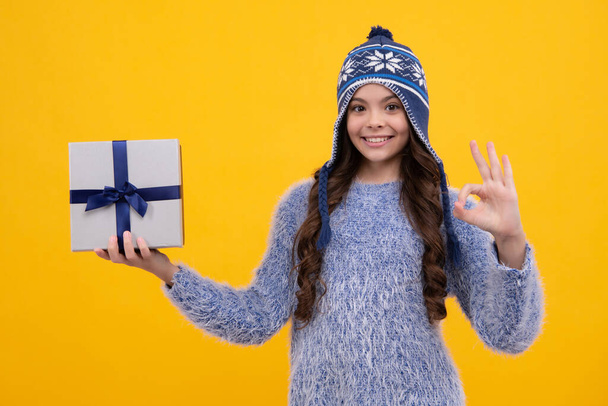Kinder im Winter tragen Geschenke für Neujahr oder Weihnachten. Glückliches Gesicht, positive und lächelnde Emotionen des Teenie-Mädchens - Foto, Bild