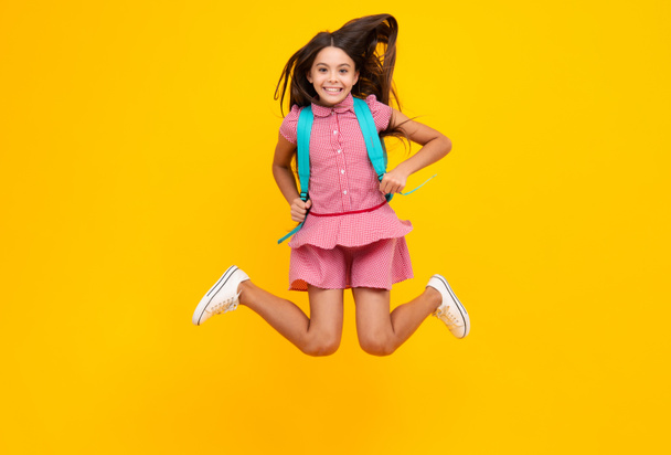 School girl with backpack. Teenager student, isolated background. Learning and knowledge. Go study. Crazy run and jump. Children education concept - Photo, Image