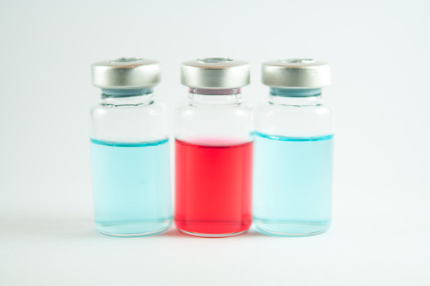 Red and blue liquid in injection vials - 写真・画像