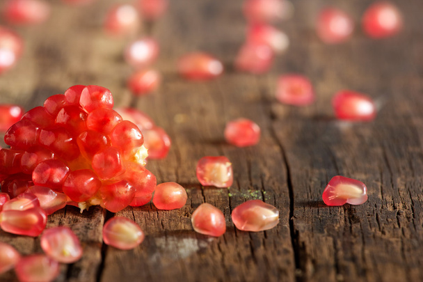 Pomegranate seeds vibrant on a wooden - Foto, Bild