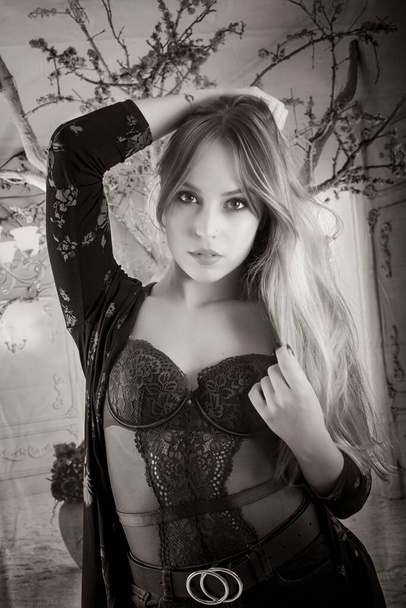 black and white portrait of a beautiful young woman with blonde hair dressed in black pants and a purple bodysuit seducing the camera sexual woman portrait - Photo, Image