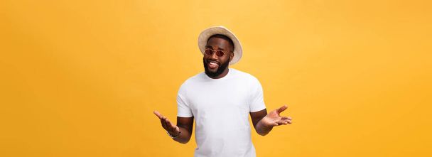 Portrait of handsome young african guy smiling in white t-shirt on yellow background. - Photo, image