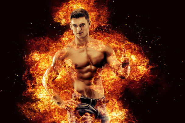 Bodybuilder posing on the fire flames background. High quality photo - Фото, изображение