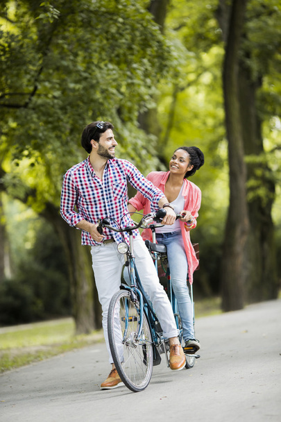 タンデム自転車に乗って若いカップル - 写真・画像
