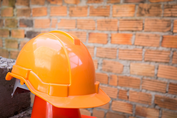 casco de seguridad sombrero duro en el sitio de construcción con pared de ladrillo
 - Foto, Imagen