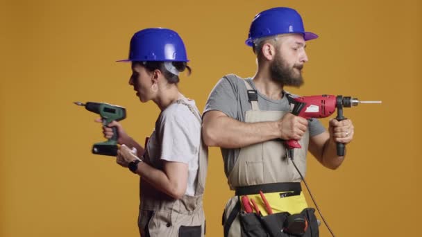Team of engineers using power drill machine to screw nails and work on construction redevelopment in studio. Builders working with electric drilling nail gun on industrial demolition. - Footage, Video