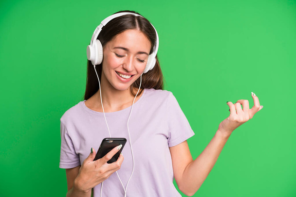 young pretty woman listening music with her headphones - Zdjęcie, obraz