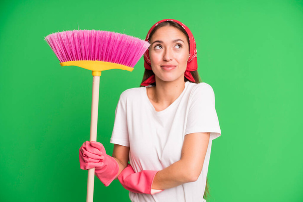 young pretty woman shrugging, feeling confused and uncertain. housekeeper and cleaning concept - Foto, afbeelding
