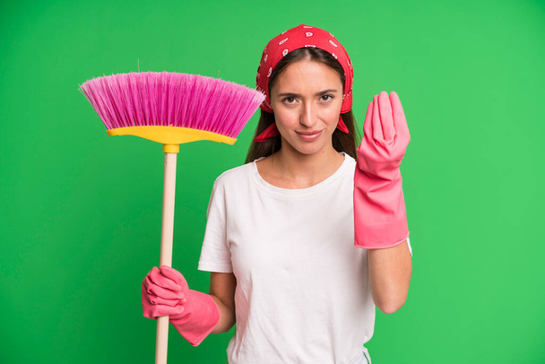 young pretty woman making capice or money gesture, telling you to pay. housekeeper and cleaning concept - Foto, imagen