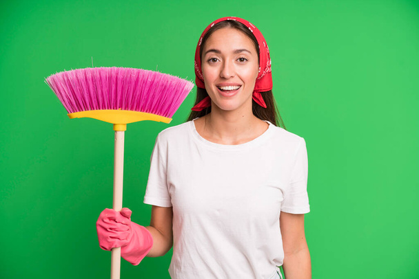 young pretty woman looking happy and pleasantly surprised. housekeeper and cleaning concept - Foto, afbeelding