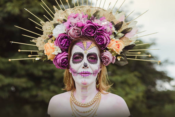 Outdoor portrait of woman made up as catrina. Mexican woman made up as catrina for day of the dead celebration. - Photo, Image