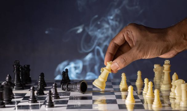 Focus sélectif sur une main humaine faisant mouvement dans le jeu d'échecs - Photo, image