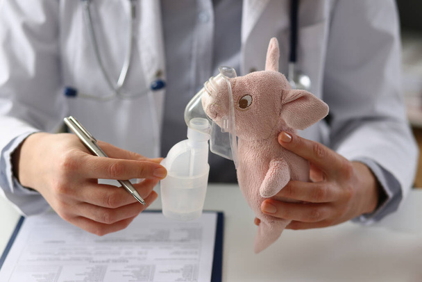 Лікар тримає іграшку з кисневою маскою в клініці. Небулайзер для дітей концепція
 - Фото, зображення
