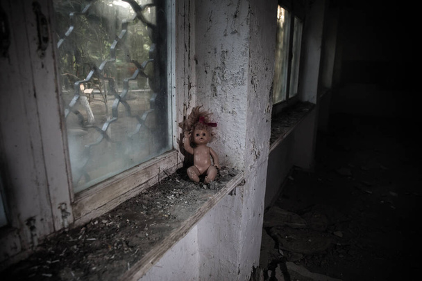 Çernobil Ukrayna 'da terk edilmiş bir evin pencere eşiğindeki eski oyuncak. Kıyamet sonrası konsepti. Seçici odak - Fotoğraf, Görsel